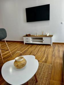 a living room with a white table and a tv at Amber L5 in Armeñime
