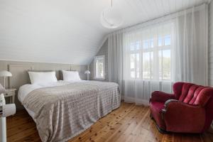 um quarto com uma cama grande e uma cadeira vermelha em Amazing Villa in Downtown Reykjavik em Reiquiavique