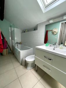 ein Badezimmer mit einem WC, einer Badewanne und einem Waschbecken in der Unterkunft Blousson in Malabat