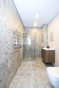 a bathroom with a shower and a toilet and a sink at Coastal Haven Retreat, By Cohost in Palanga