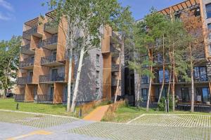 a large building with trees in front of it at Coastal Haven Retreat, By Cohost in Palanga