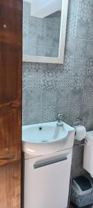 een badkamer met een witte wastafel en een spiegel bij Bobića konak - Lukomir in Lukomir