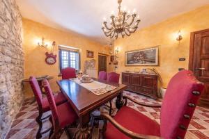 ein Esszimmer mit einem Holztisch und roten Stühlen in der Unterkunft Villa Paradiso - Irpinia in Gesualdo