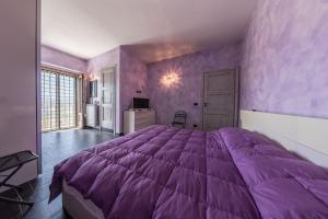 ein lila Schlafzimmer mit einem großen Bett darin in der Unterkunft Villa Paradiso - Irpinia in Gesualdo