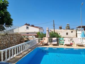 a swimming pool with lounge chairs and an umbrella at Kalkan Centre Bijou Home - Walk to town and beach in Kalkan