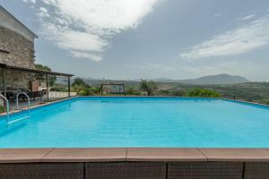 a large blue swimming pool with mountains in the background at Villa Paradiso - Irpinia in Gesualdo