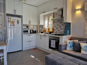 a kitchen with white cabinets and a stove top oven at Kalkan Centre Bijou Home - Walk to town and beach in Kalkan