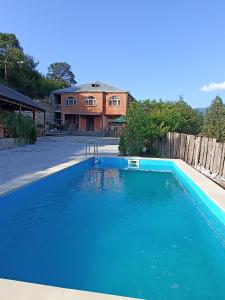 a large blue swimming pool in front of a house at Green Garden in Ijevan