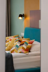 a bedroom with a bed with colorful pillows on it at Stylish Apartment Warsaw Downtown by Renters in Warsaw