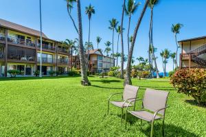 two chairs in the grass in front of a resort at Kona Isle B5 in Kailua-Kona