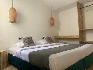 a bedroom with a large bed with two pillows at Hotel Quintas de Normandia in Bogotá