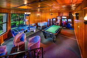 a room with a pool table and several video games at Alfaresort Palace Chiflika in Chiflik