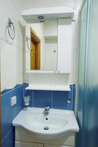uma casa de banho com um lavatório branco e um espelho. em Apartment GOLD em Podgorica