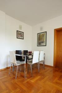 uma sala de jantar com uma mesa e cadeiras brancas em Apartment GOLD em Podgorica