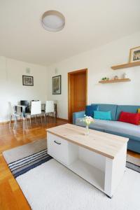 uma sala de estar com um sofá azul e uma mesa em Apartment GOLD em Podgorica