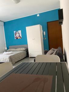 una camera con due letti e una parete blu di HOLIDAY PATRIZIA'S HOME a San Giorgio Ionico