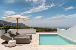un patio con sombrilla y piscina en Arotron Santorini, en Pirgos