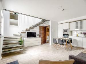 a living room with a staircase and a table and chairs at Ultracentral modern apartment in Târgu-Mureş