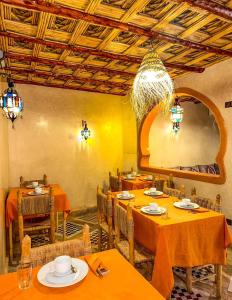 um restaurante com mesas e cadeiras cor de laranja e um lustre em RIAD AMNAY em Taroudant