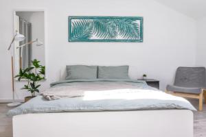 a white bedroom with a bed and a chair at Ultracentral modern apartment in Târgu-Mureş
