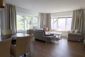 a living room with a couch and a table and chairs at Ferienwohnungen BergArt in Iselsberg