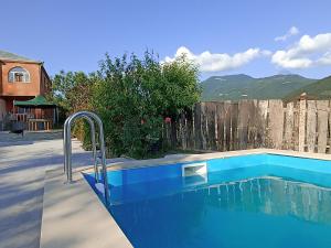 a blue swimming pool next to a wooden fence at Green Garden in Ijevan