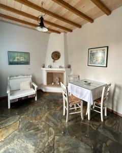 a dining room with a table and chairs and a fireplace at ORPHEAS TRADITIONAL HOUSE in Alonnisos
