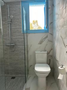 ein Bad mit einem WC, einem Fenster und einer Dusche in der Unterkunft ORPHEAS TRADITIONAL HOUSE in Alonnisos Altstadt