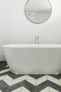 a bathroom with a white tub and a mirror at The Millbrook Inn in Kingsbridge