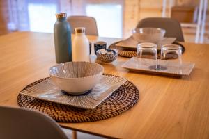 a wooden table with plates and bowls and vases on it at Tiny House - Gilda e i suoi amici in Neive