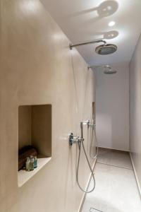 a bathroom with a shower with a shower head at Arotron Santorini in Pirgos