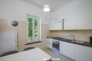 een keuken met witte kasten, een wastafel en een raam bij Nettuno, TerreMarine in Monterosso al Mare