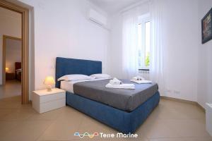 een slaapkamer met een blauw bed en een raam bij Nettuno, TerreMarine in Monterosso al Mare