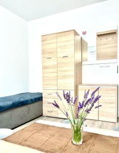 sypialnia z łóżkiem i wazonem z fioletowymi kwiatami w obiekcie Dom nad Jeziorami w mieście Łubowo