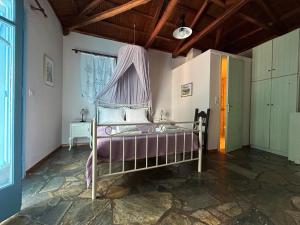 a bedroom with a bed with a canopy at ELECTRA TRADITIONAL HOUSE in Alonnisos