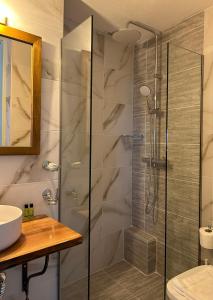 a bathroom with a glass shower and a sink at ELECTRA TRADITIONAL HOUSE in Alonnisos