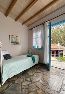 a bedroom with a bed and a window at ELECTRA TRADITIONAL HOUSE in Alonnisos