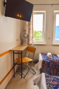 ワルシャワにあるArcus Premium Hostelのデスク、ベッド、窓が備わる客室です。
