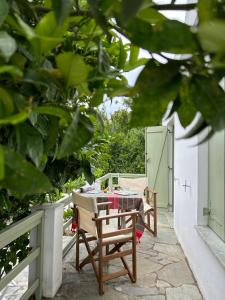 a table and chairs on a patio with trees at Nefeli Traditional House in Alonnisos