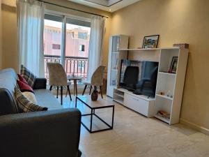 sala de estar con sofá y TV en Bright Apt in the Heart of Marrakech-Walk Everywhere en Marrakech