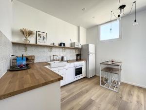 una cucina con armadietti bianchi e frigorifero di Charmant appartement rénové - Central & Spacieux - Les Frères de la Loc' a Marsiglia