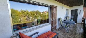 a screened in porch with a large window and a table at Moderne120qm Ferienwohnung in ruhiger Lage Heusweiler - Saarland in Heusweiler