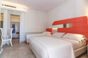 2 camas en un dormitorio con cabecero rojo en Agave Blu, en San Nicolò