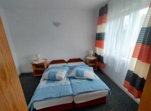 a bedroom with two beds and two windows at Pokoje u Małgosi in Kosewo