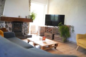 - un salon avec un canapé et une télévision dans l'établissement Maison Paradis - Piscine - BY PRIMO C0NCIERGERIE, à Saint-Didier-sur-Beaujeu