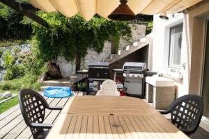 - une table et des chaises sur une terrasse avec barbecue dans l'établissement Maison Paradis - Piscine - BY PRIMO C0NCIERGERIE, à Saint-Didier-sur-Beaujeu