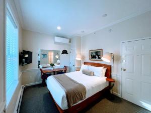 um quarto com uma cama com uma secretária e uma cama sidx sidx em Copley House em Boston