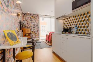 une cuisine avec un comptoir et une table avec des chaises dans l'établissement Theater Studio, à Porto