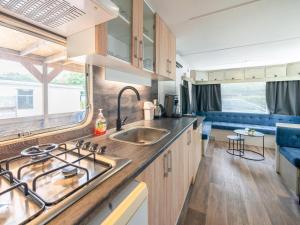 a kitchen with a sink and a stove at Cozy holiday home in Hoogeveen with garden in De Bult