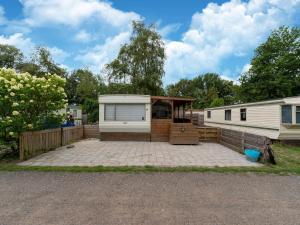a mobile home with a patio in front of it at Cozy holiday home in Hoogeveen with garden in De Bult